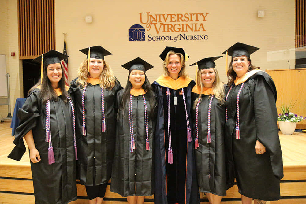 A Group Of Women In Graduation Gowns Posing For A Photo