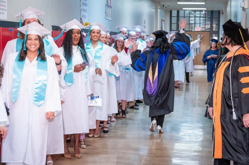 A Group Of Graduates Walking Down A Hallway