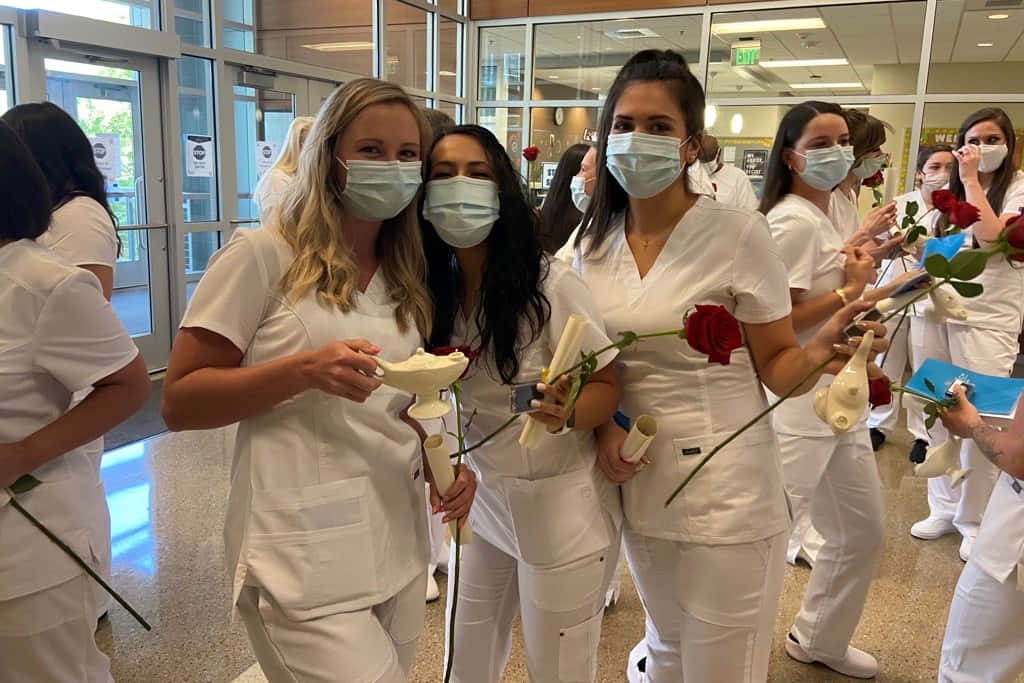A Group Of Nurses In White Masks Holding Roses