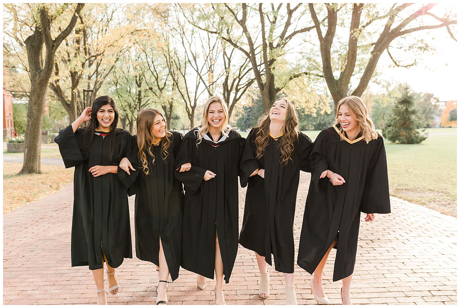 A Group Of Women In Black Graduation Gowns Are Laughing