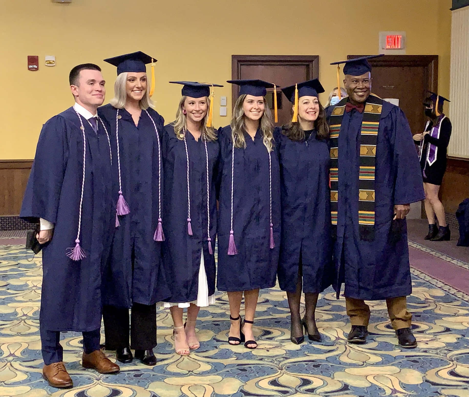 A Group Of People In Graduation Gowns Posing For A Photo