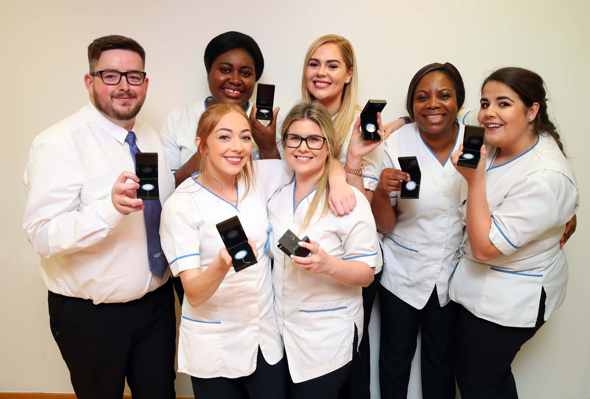A Group Of Nurses Posing With Their Phones