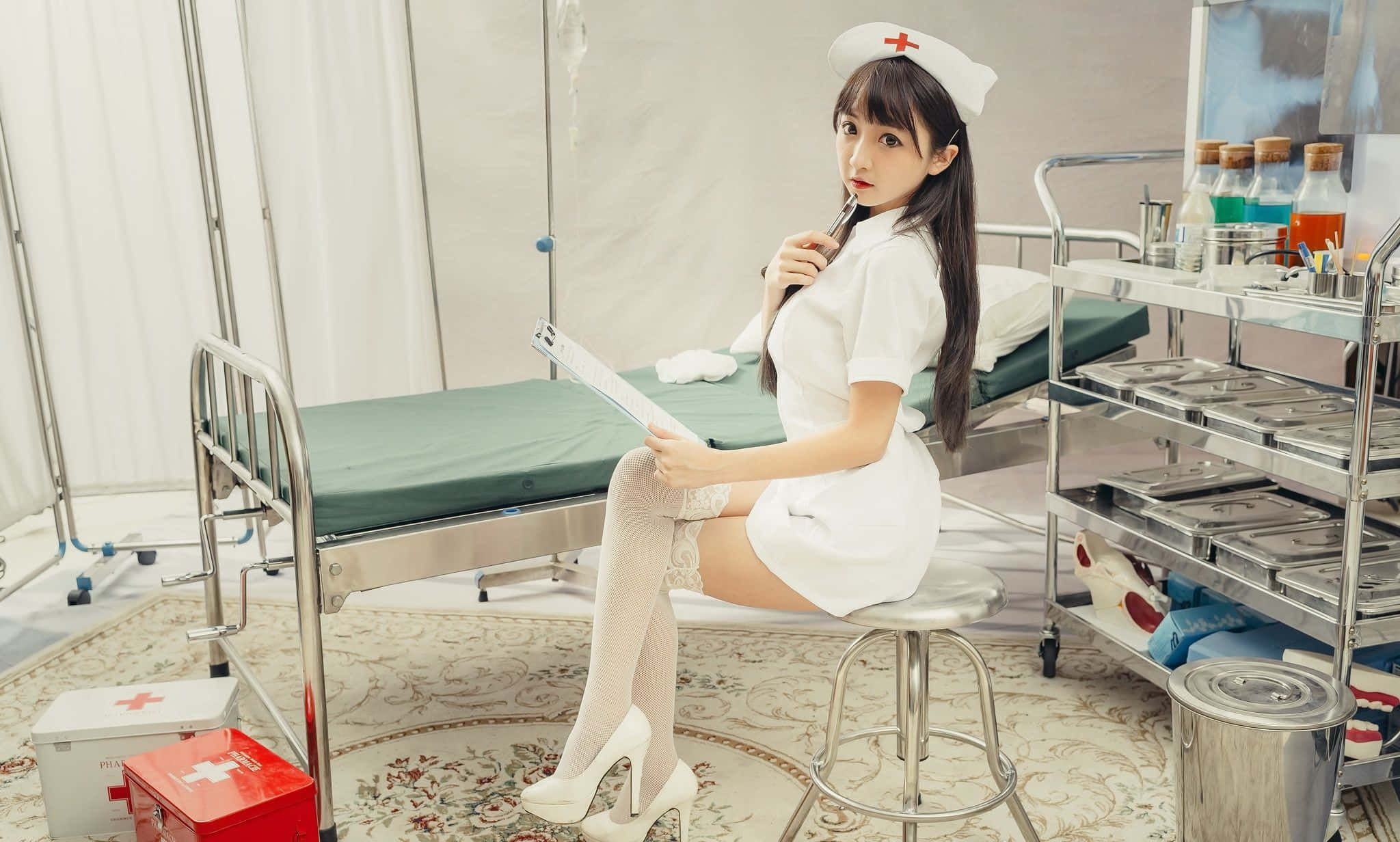 A Nurse Sitting On A Stool In A Hospital Room