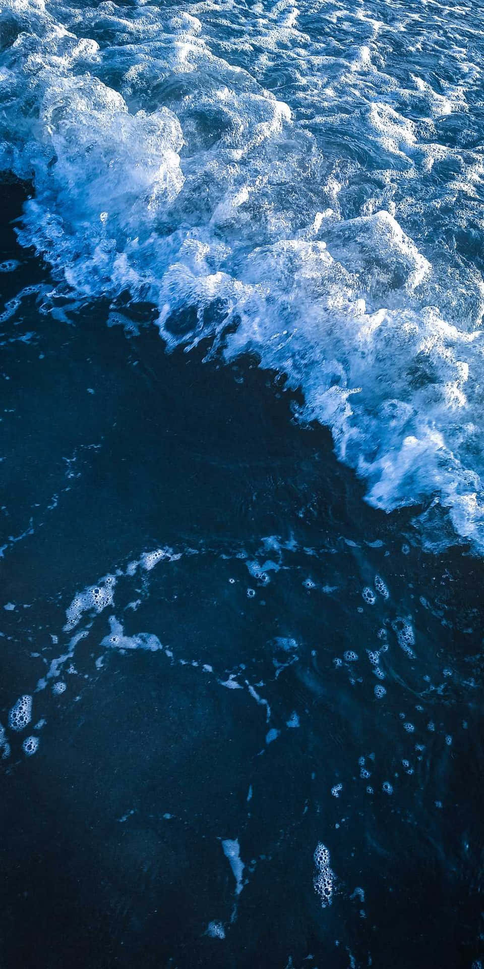 Unahermosa Puesta De Sol En El Océano Reflejada En La Superficie De Un Teléfono Celular Fondo de pantalla