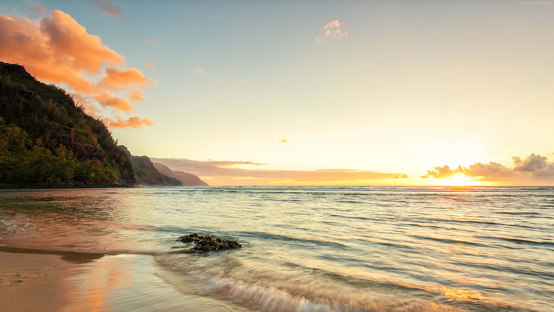 A Serene Sunrise Over Ocean Beach Wallpaper