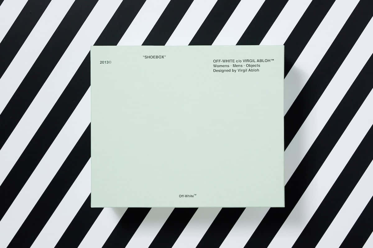 A Green Notebook On A Black And White Striped Background Wallpaper