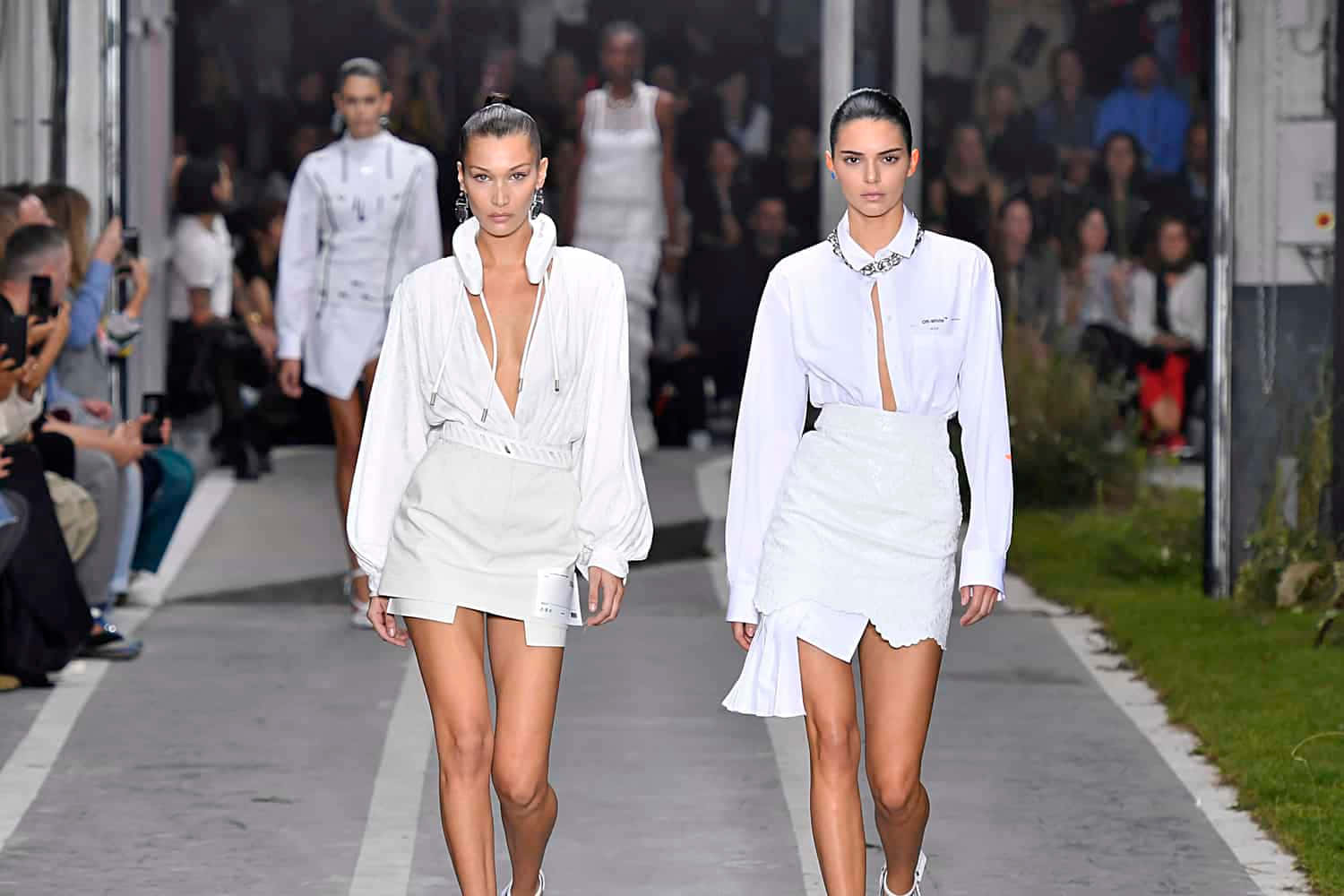 To kvinder, der går ned ad catwalken i hvide shorts.