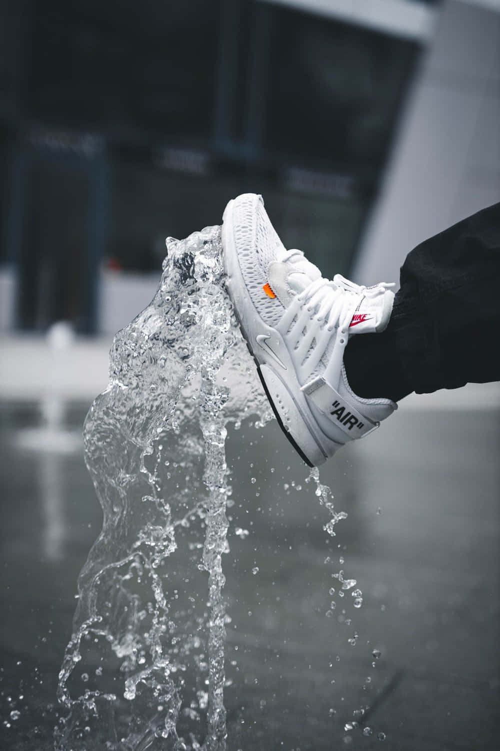 En person står foran en fontæne med et par sneakers Wallpaper