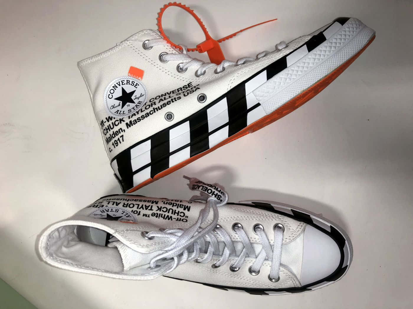 A Pair Of White Converse Sneakers With Orange And Black Stripes Wallpaper