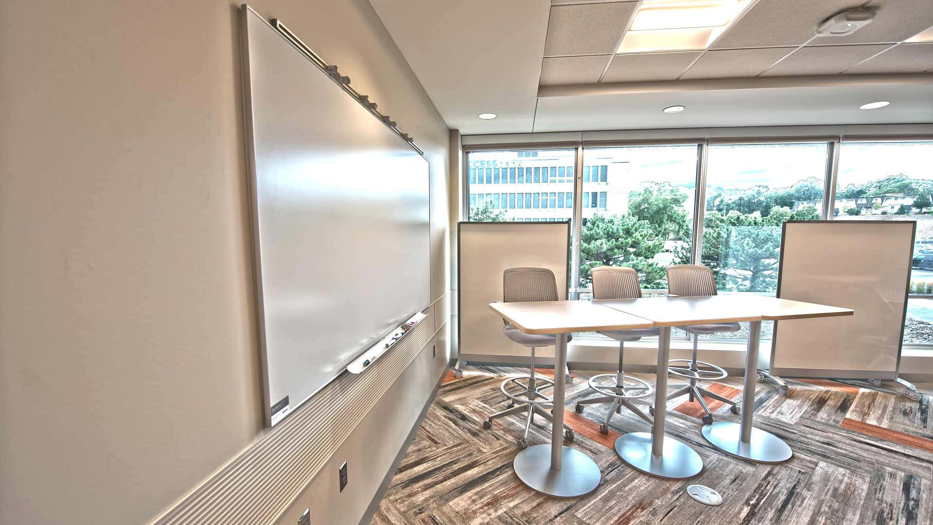 A Conference Room With A White Board And Chairs