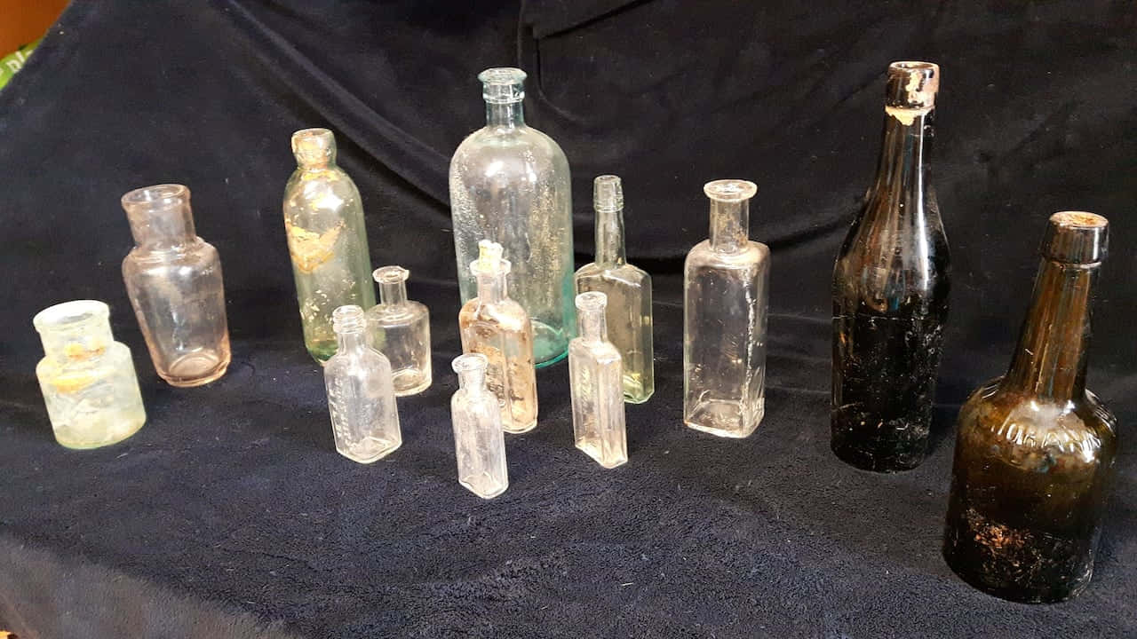 A Group Of Old Bottles On A Table