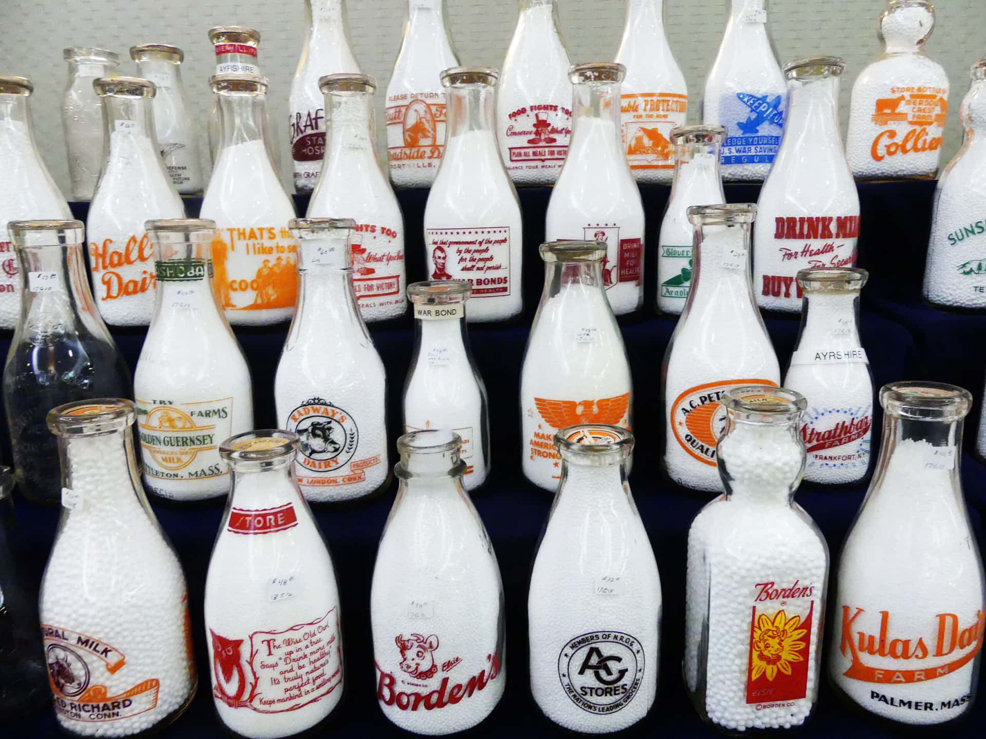 A Display Of Milk Bottles With Different Designs