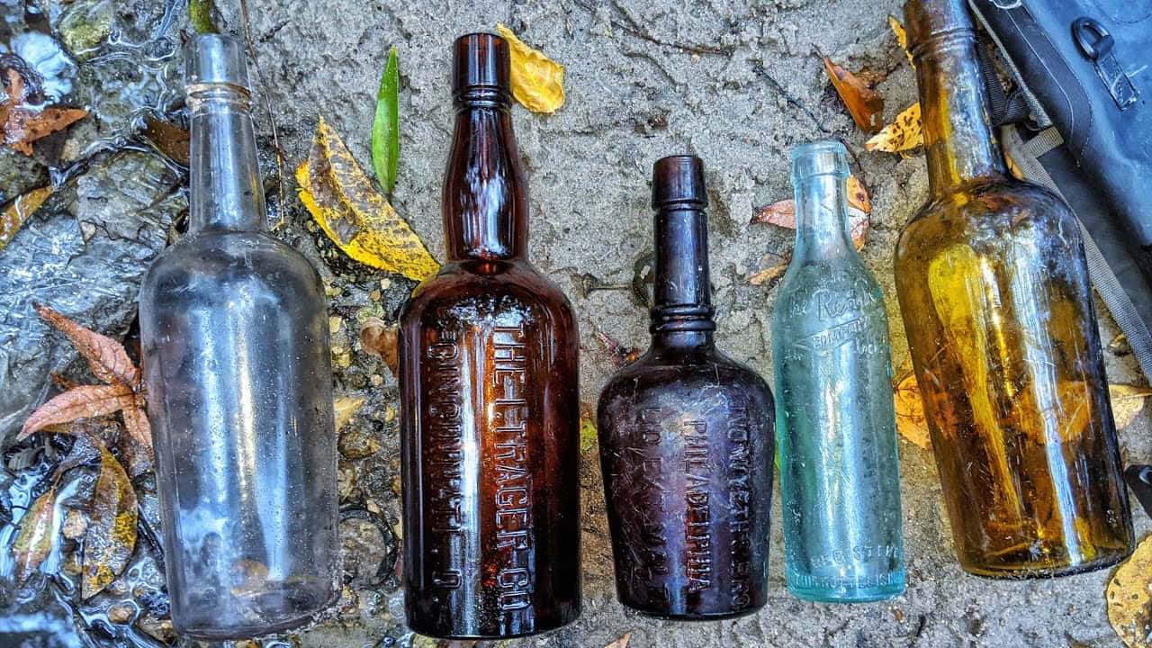 A Group Of Old Bottles On The Ground