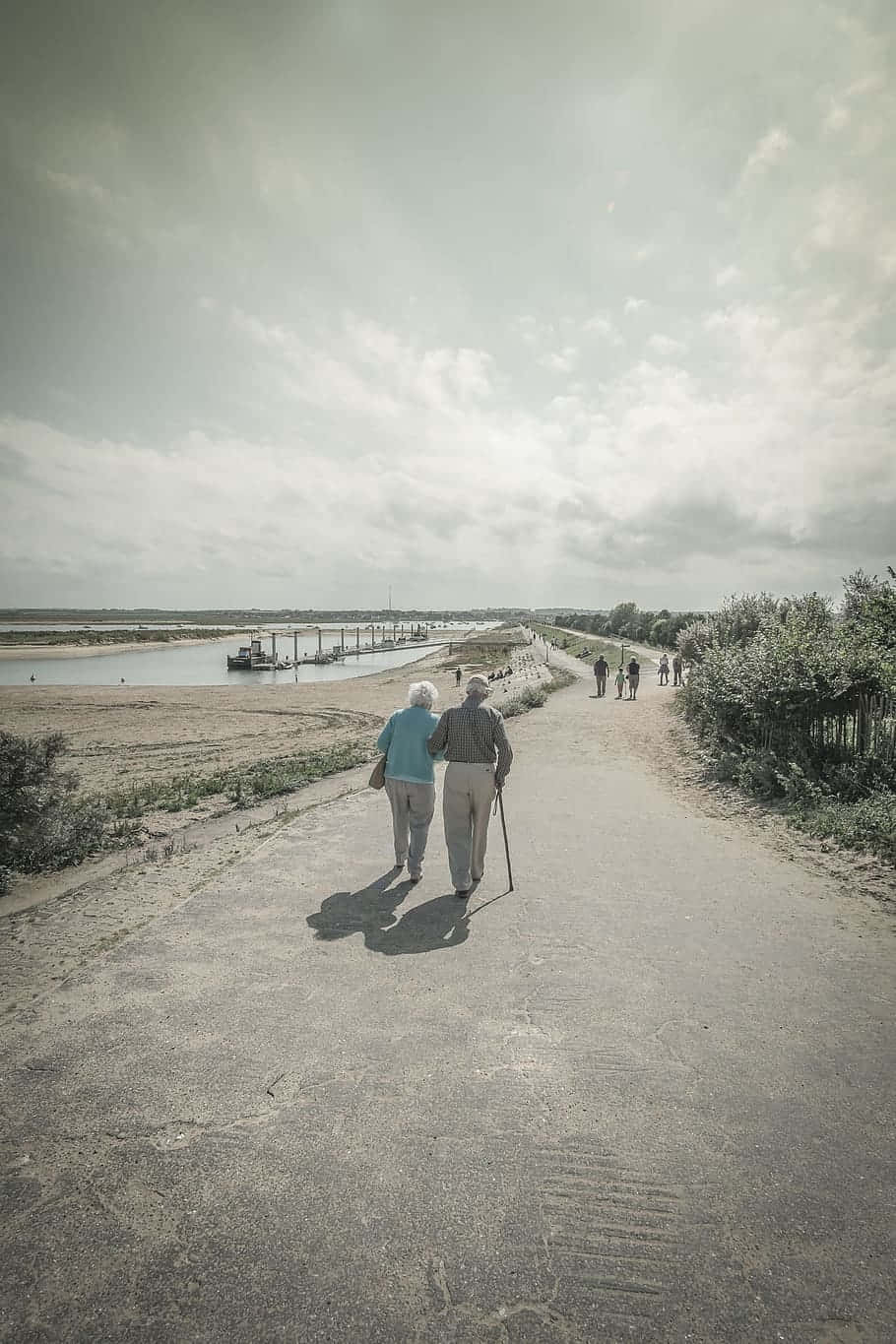 Casalde Idosos Caminhando À Beira-mar. Papel de Parede
