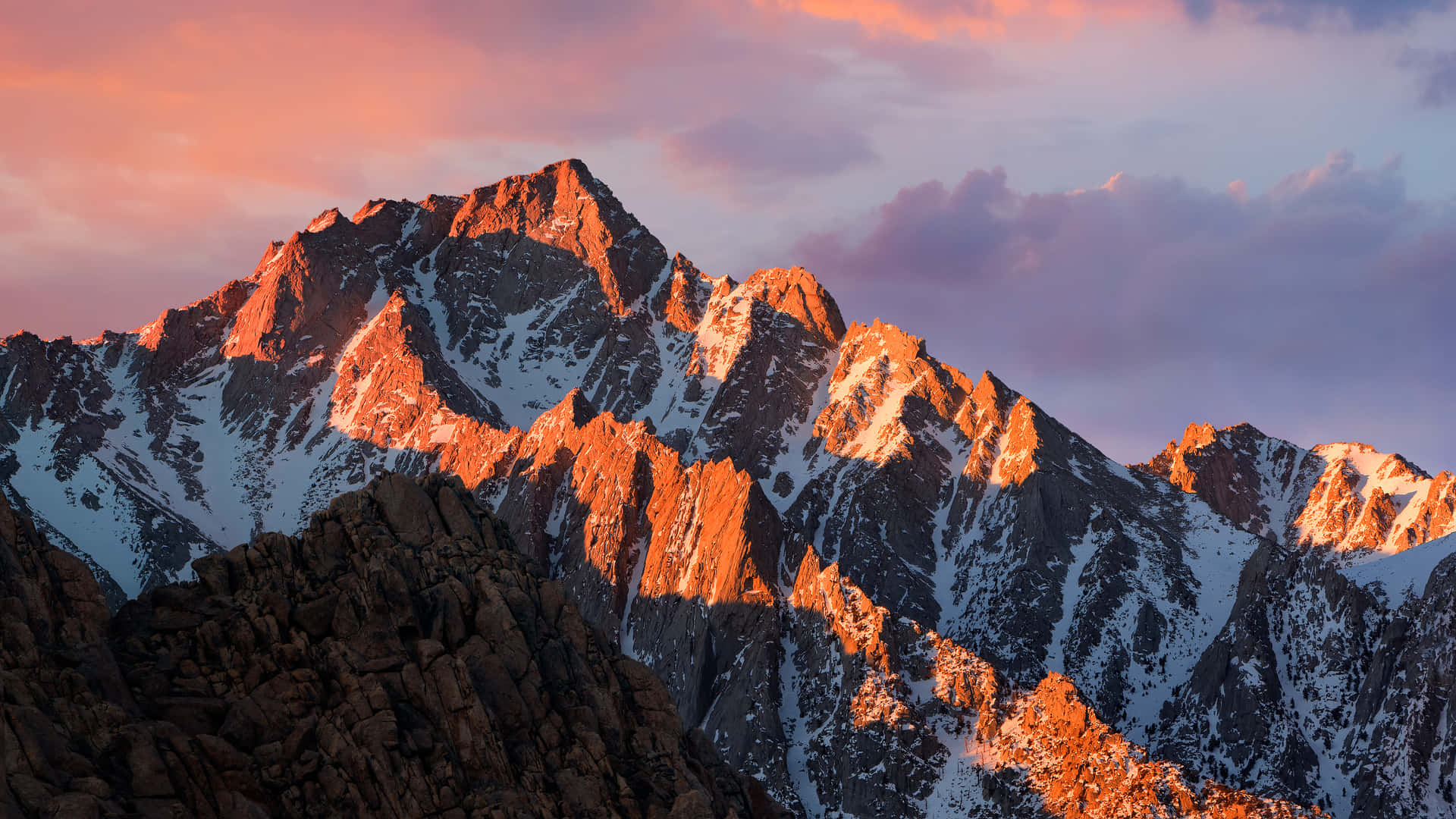 En bjergkæde med et solnedgangsbaggrund. Wallpaper
