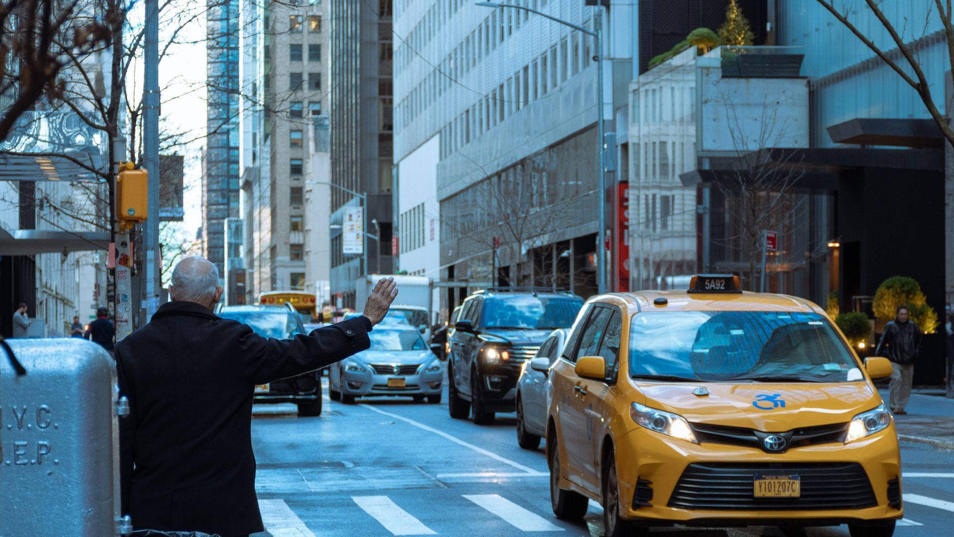 Senior Man Signaling Taxi in City Wallpaper