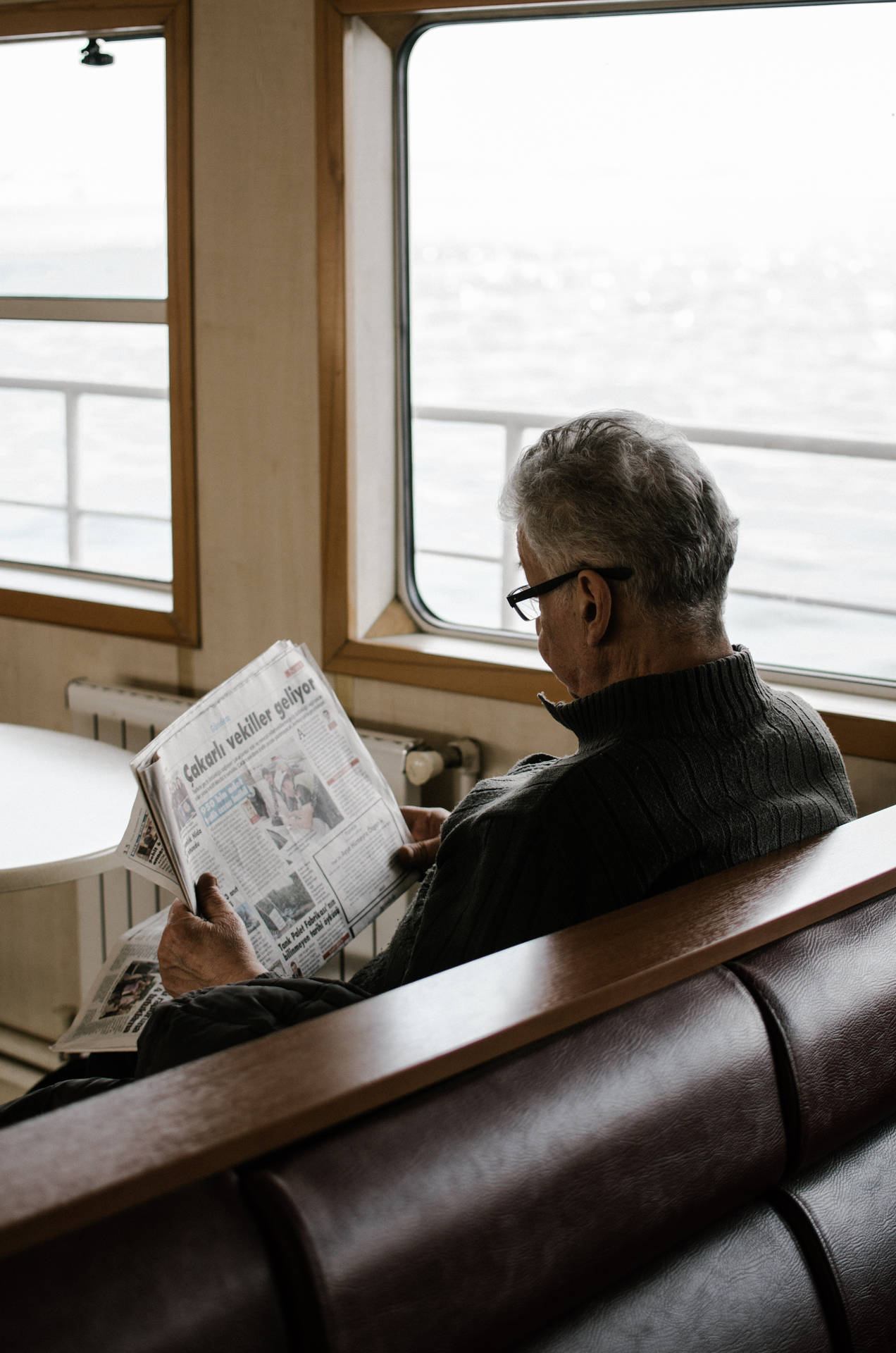 Hombremayor Leyendo Periódico En Un Barco. Fondo de pantalla