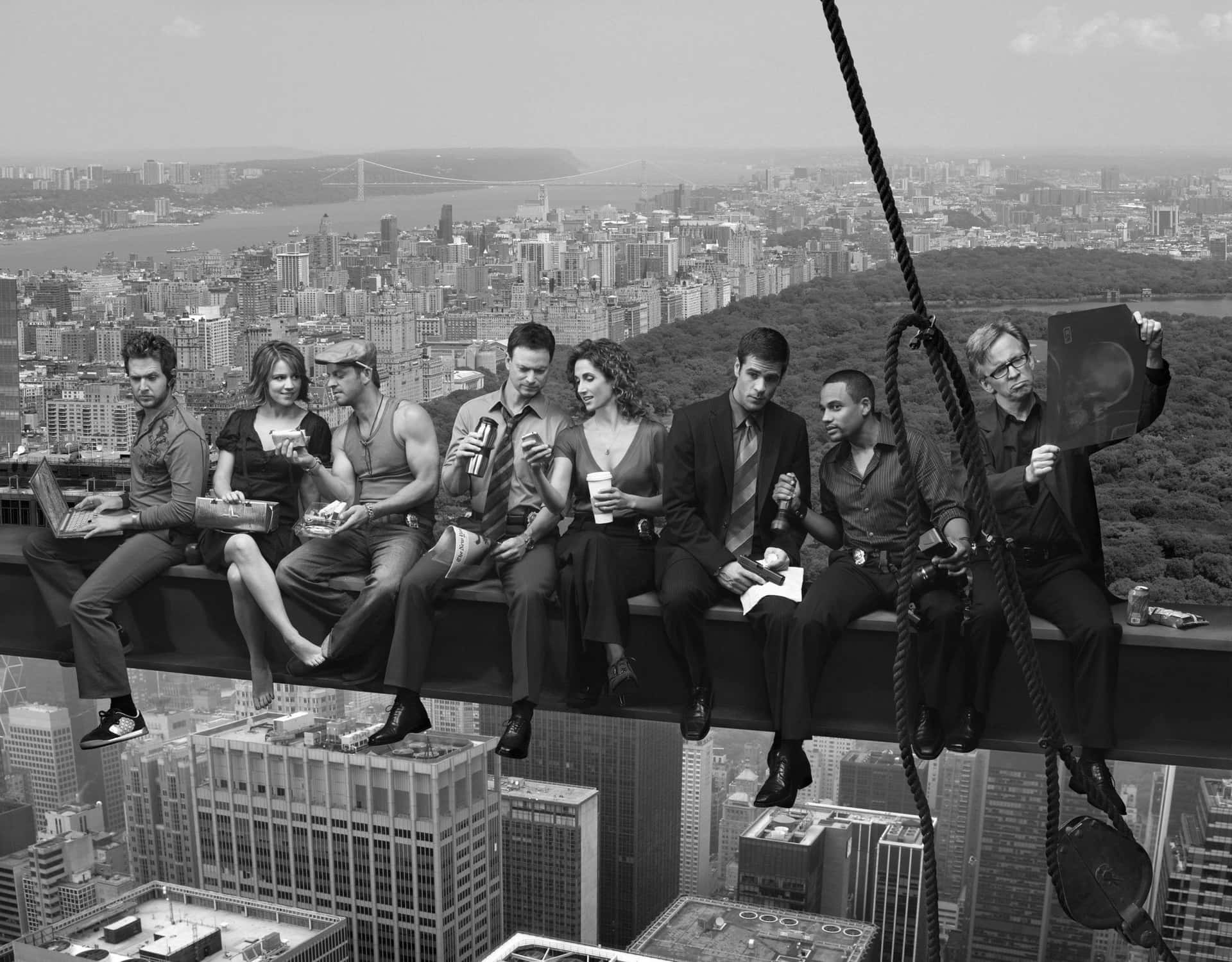 Et gruppe mennesker siddende på en kant med udsigt over byens skyline. Wallpaper