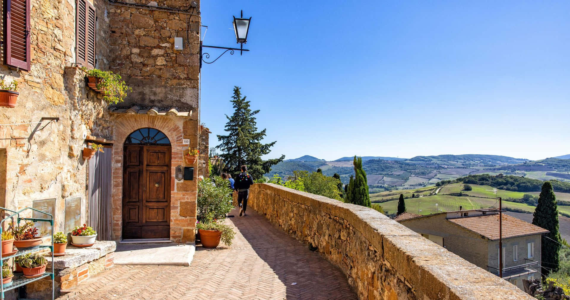 Old Pienza Brick House With Mountain Scenery Wallpaper