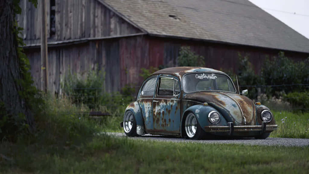 A Rusty Old Vw Beetle Sitting On A Road Wallpaper