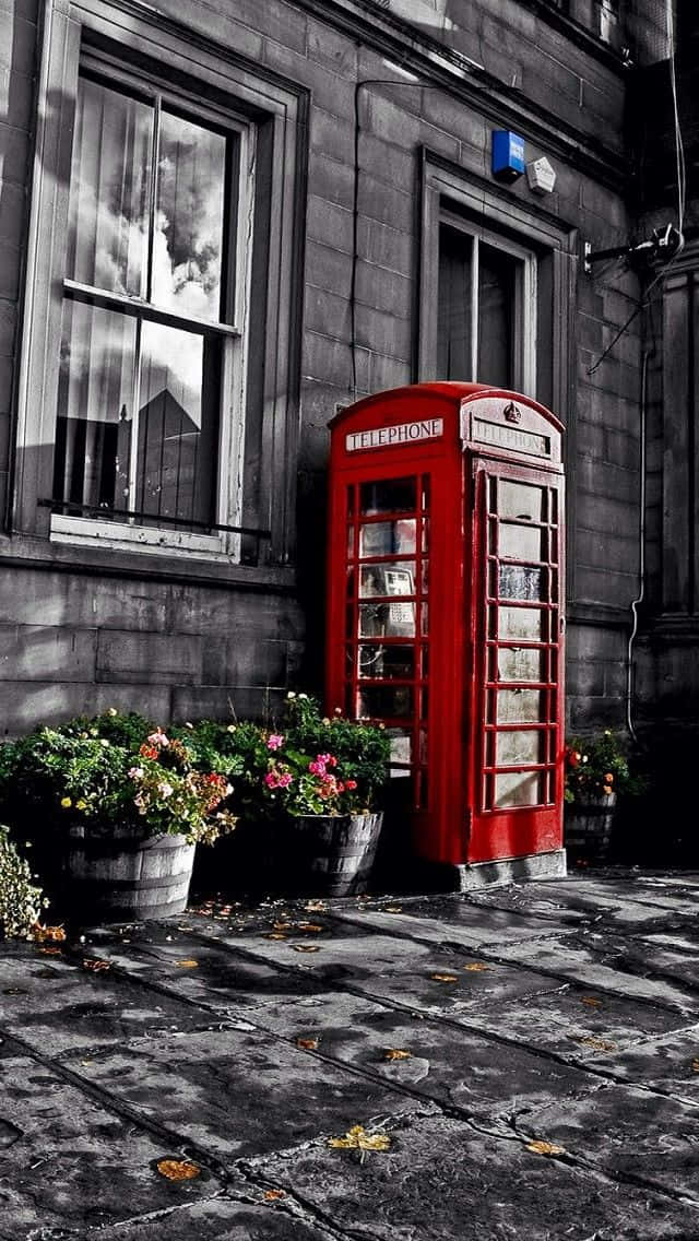 A Red Telephone Booth In Front Of A Building Wallpaper
