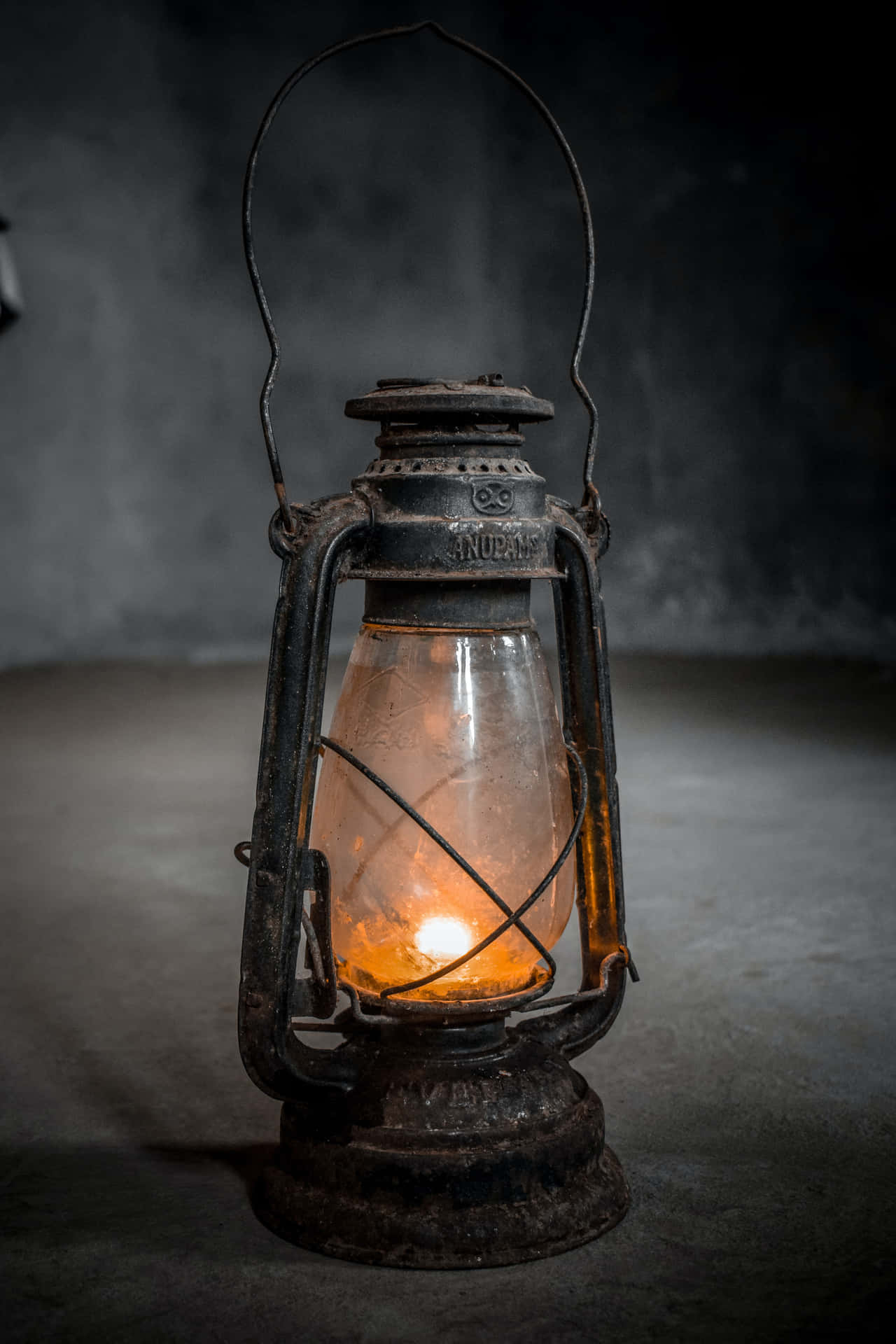 An Old Lantern Is Lit In A Dark Room Wallpaper