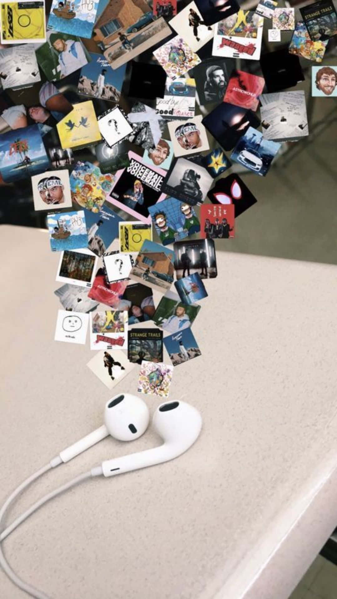 A Table With Earphones And Pictures Hanging From It Wallpaper