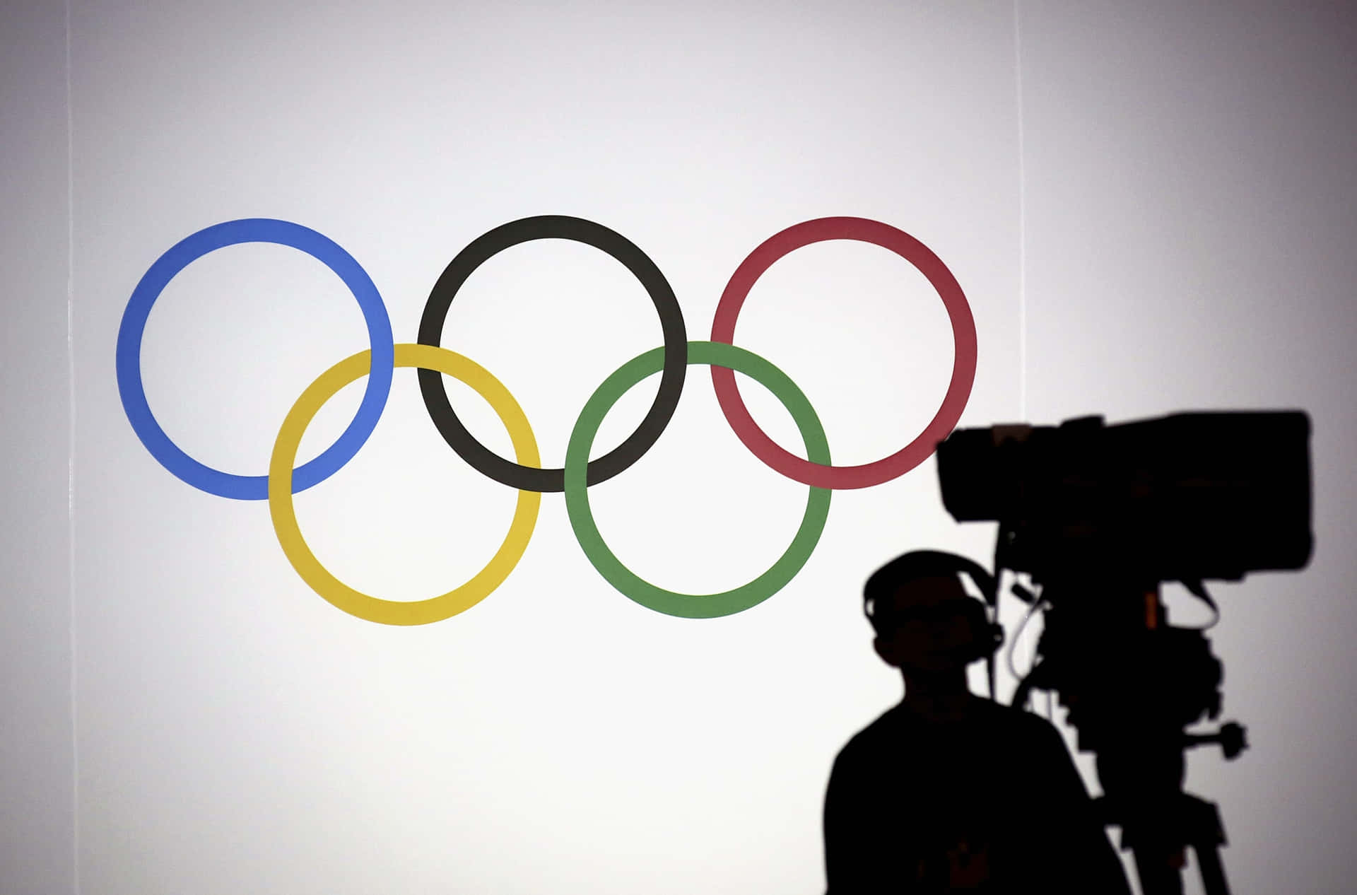 A Man Is Standing In Front Of An Olympics Sign