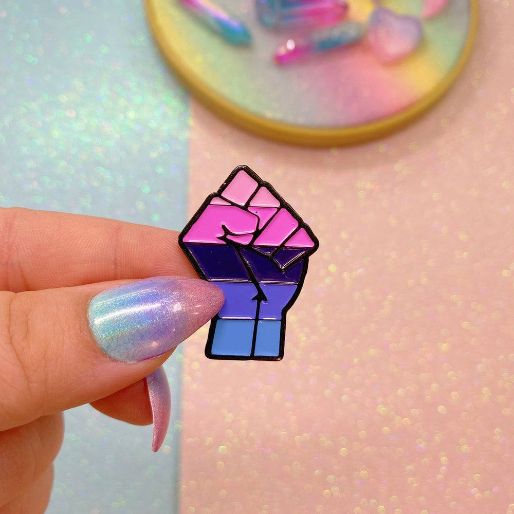 A Person Holding A Pin With A Rainbow Fist Wallpaper