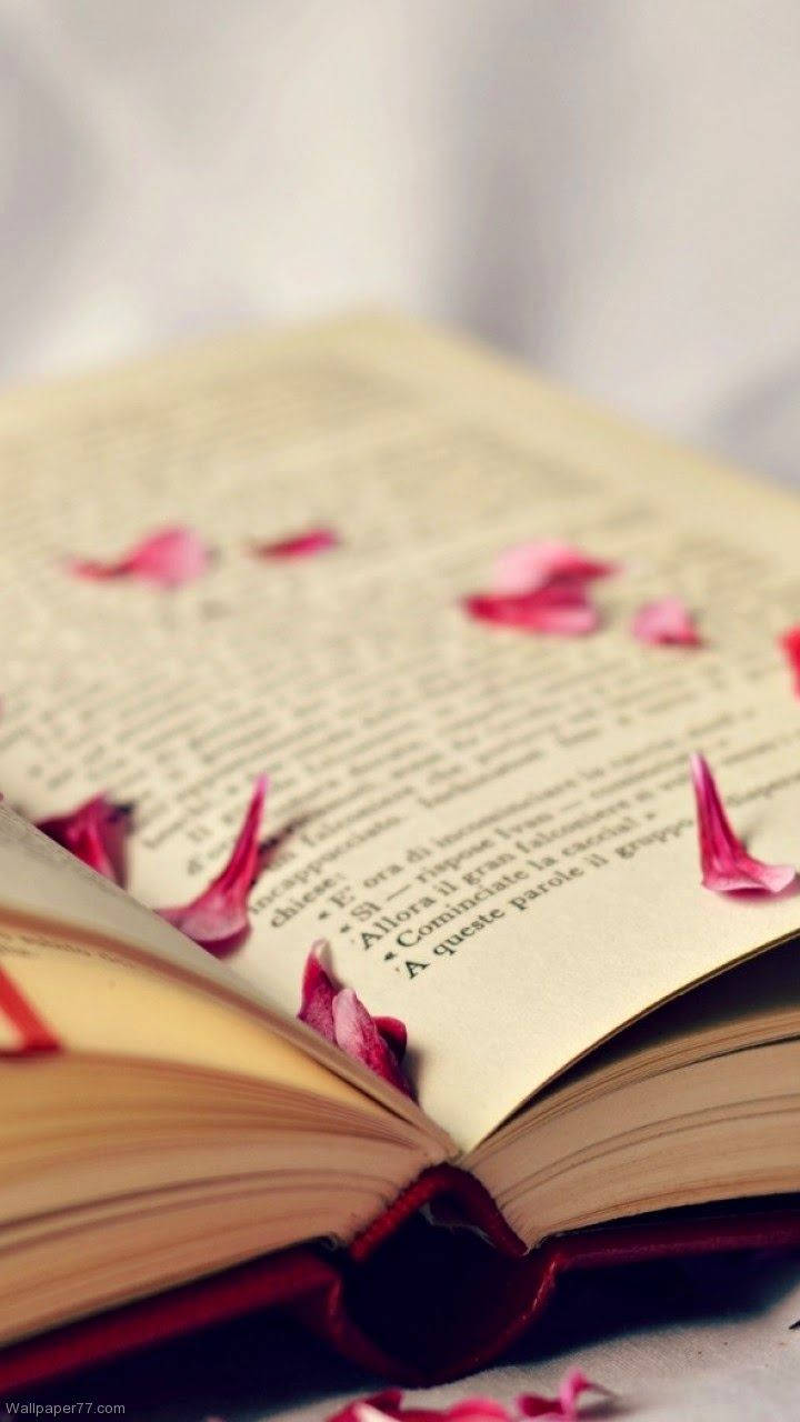 Open book with scattered pink petals wallpaper