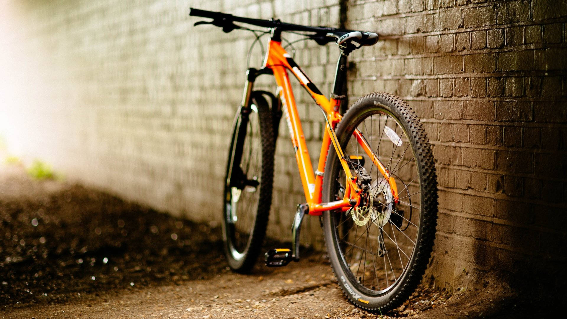 Orange Bicycle By A Wall Background