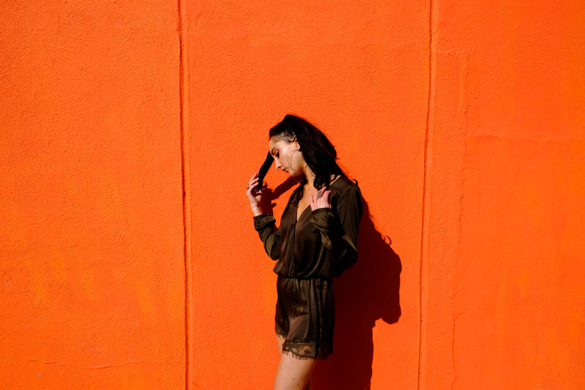 Fashion shot of a girl in orange wallpaper.