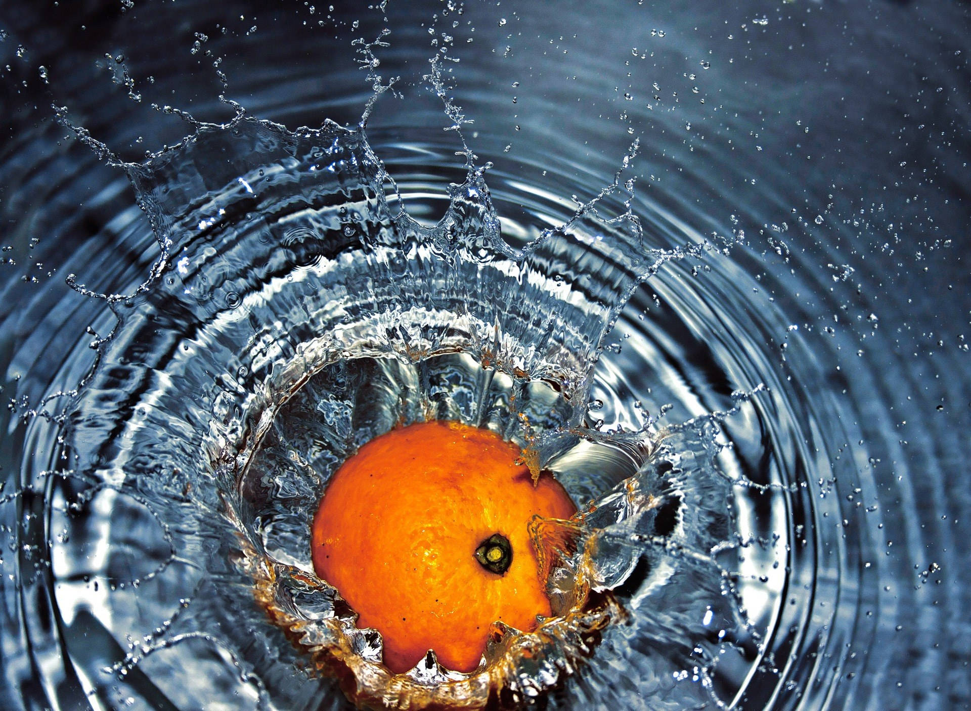 Frutade Naranja Cayendo En El Agua. Fondo de pantalla