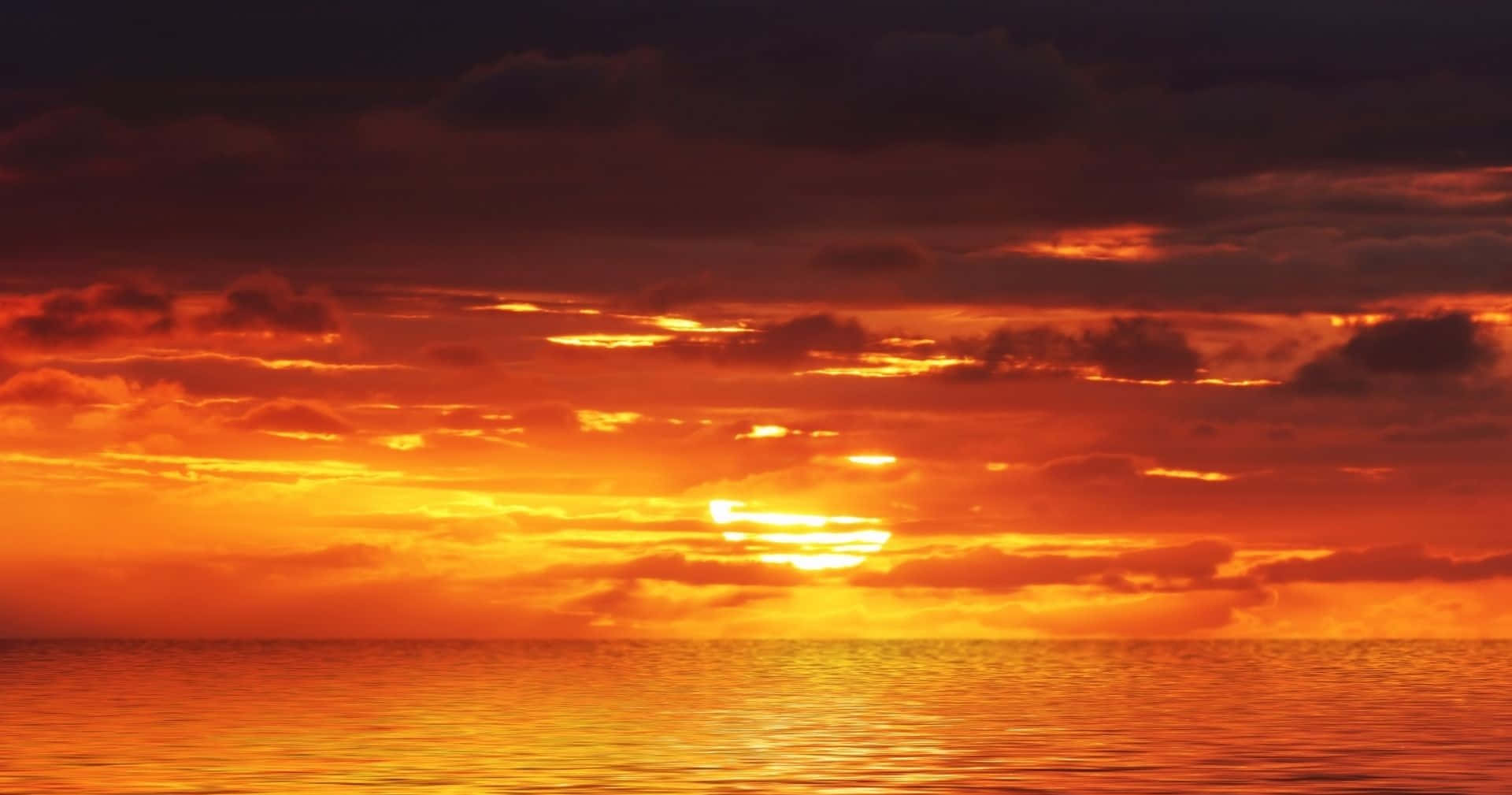 Breathtaking Orange Sunset Over a Calm Sea Wallpaper