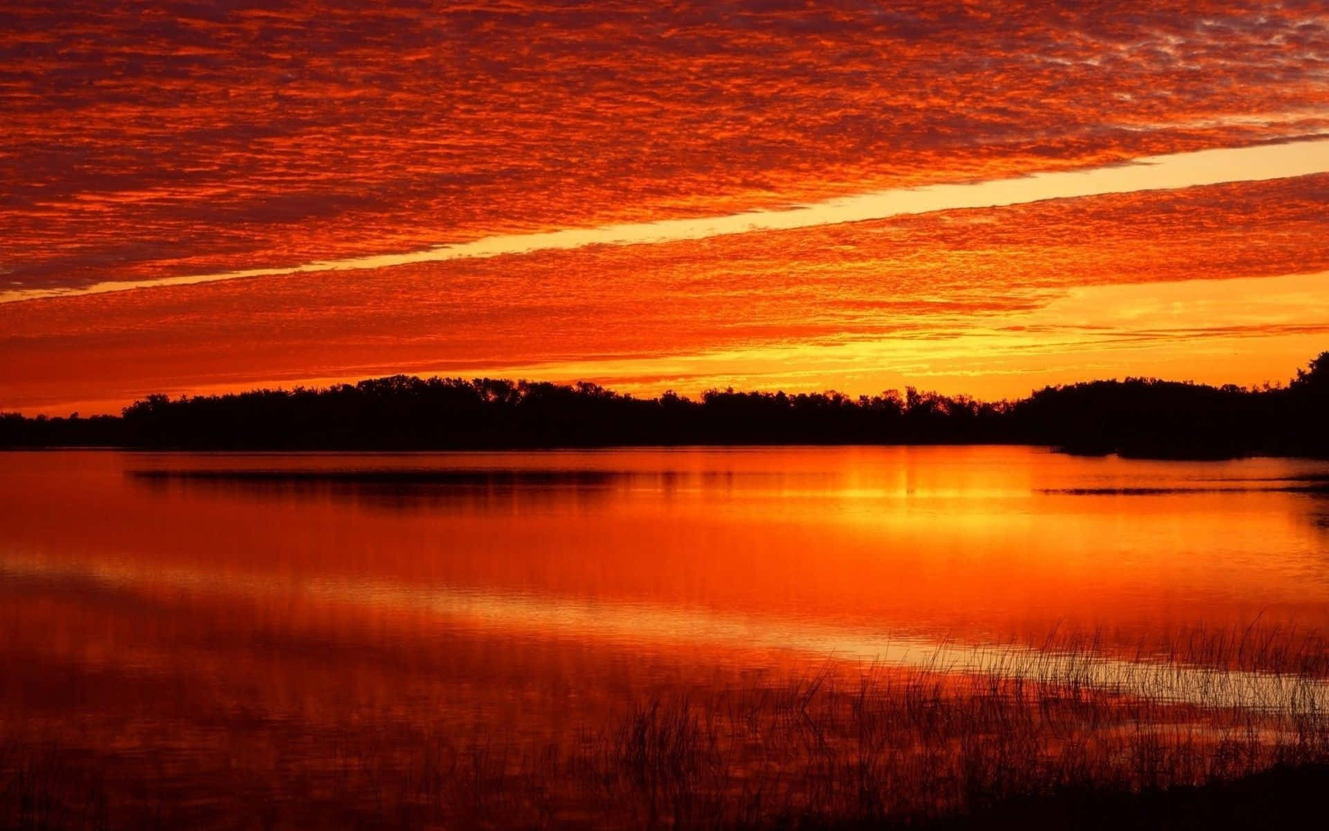 Caption: Majestic Orange Sunset Wallpaper