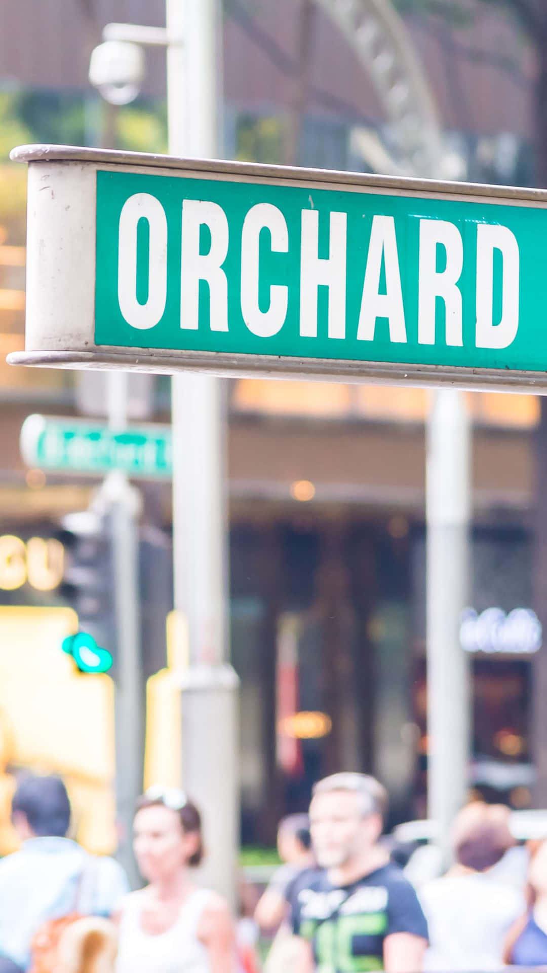 Orchard_ Road_ Sign_ Above_ Crowded_ Street_ Scene Wallpaper