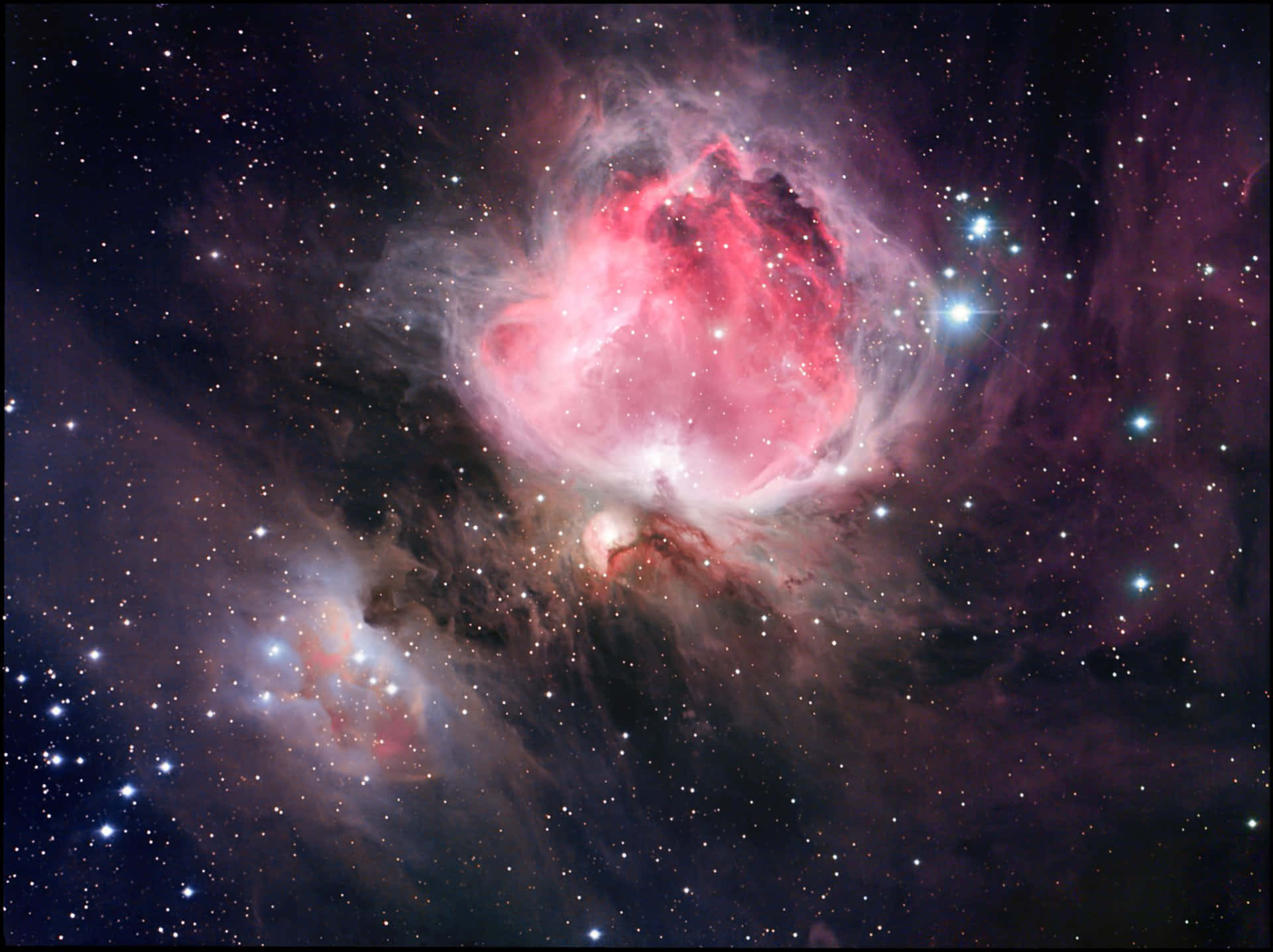 A Pink Nebula With Stars In The Background
