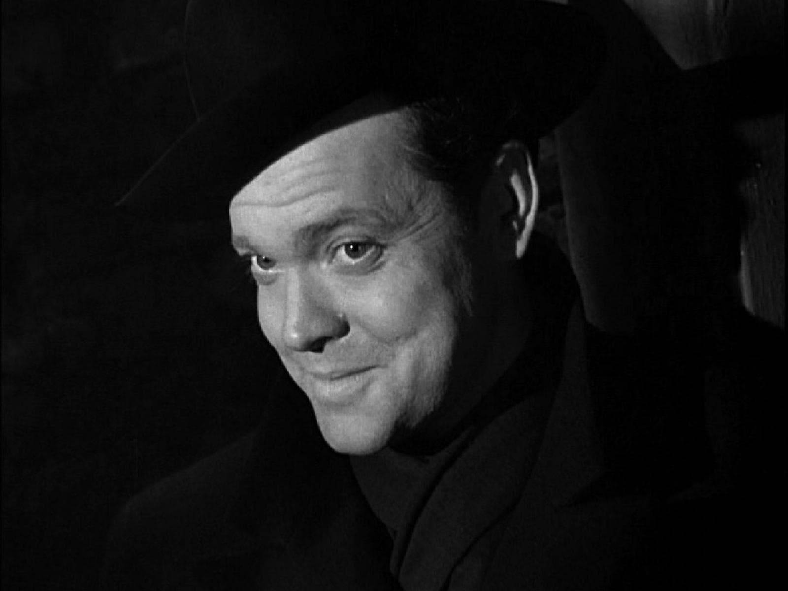 Orson Welles, a figure of classic cinema, adorned in black. Wallpaper