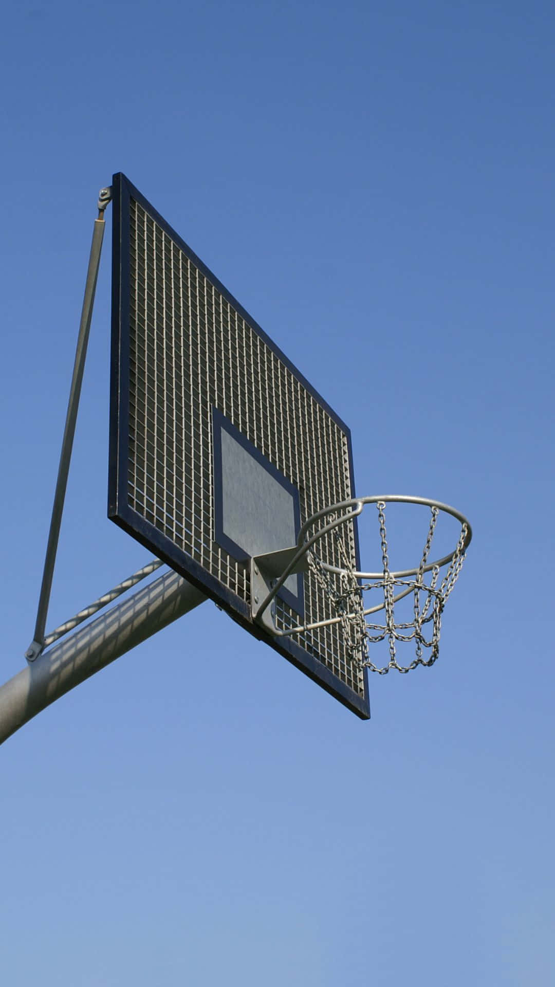 Outdoor Basketball Hoop Against Blue Sky Wallpaper