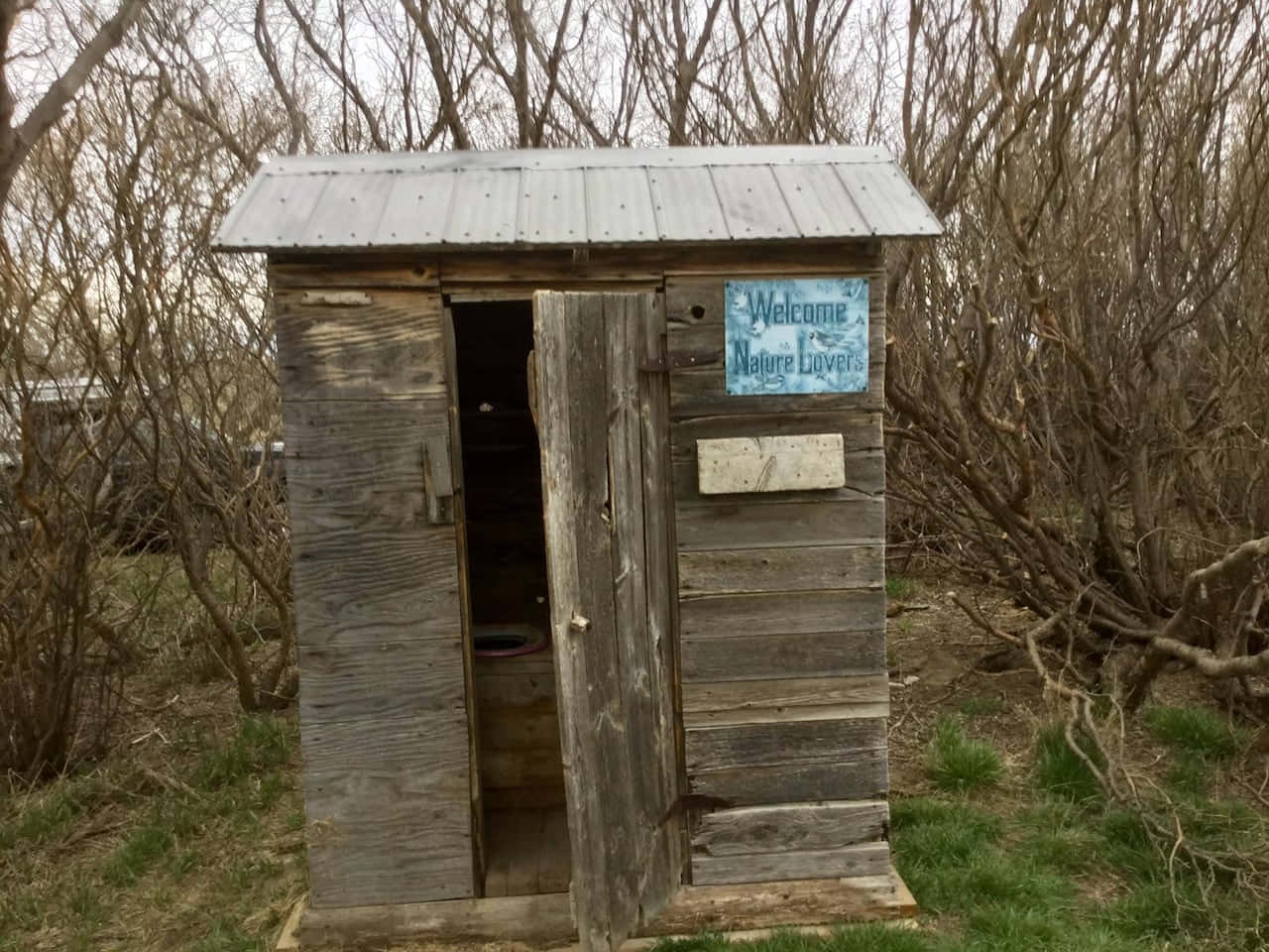 A Traditional Outhouse Set Amidst a Rural Landscape