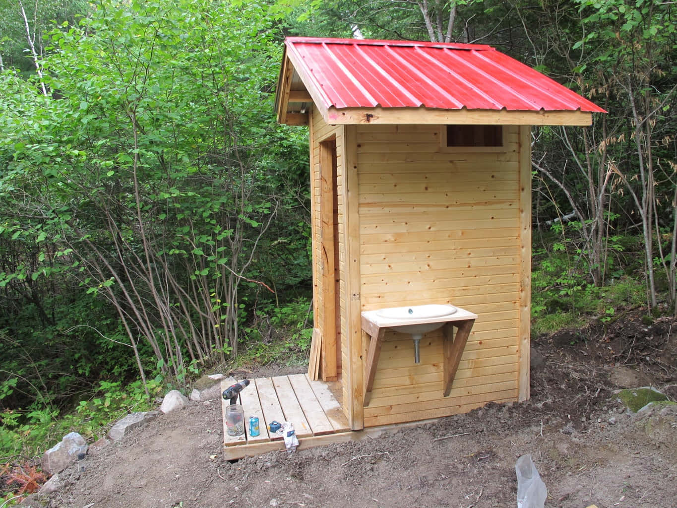 Out in The Open: An idyllic picture of a white Outhouse