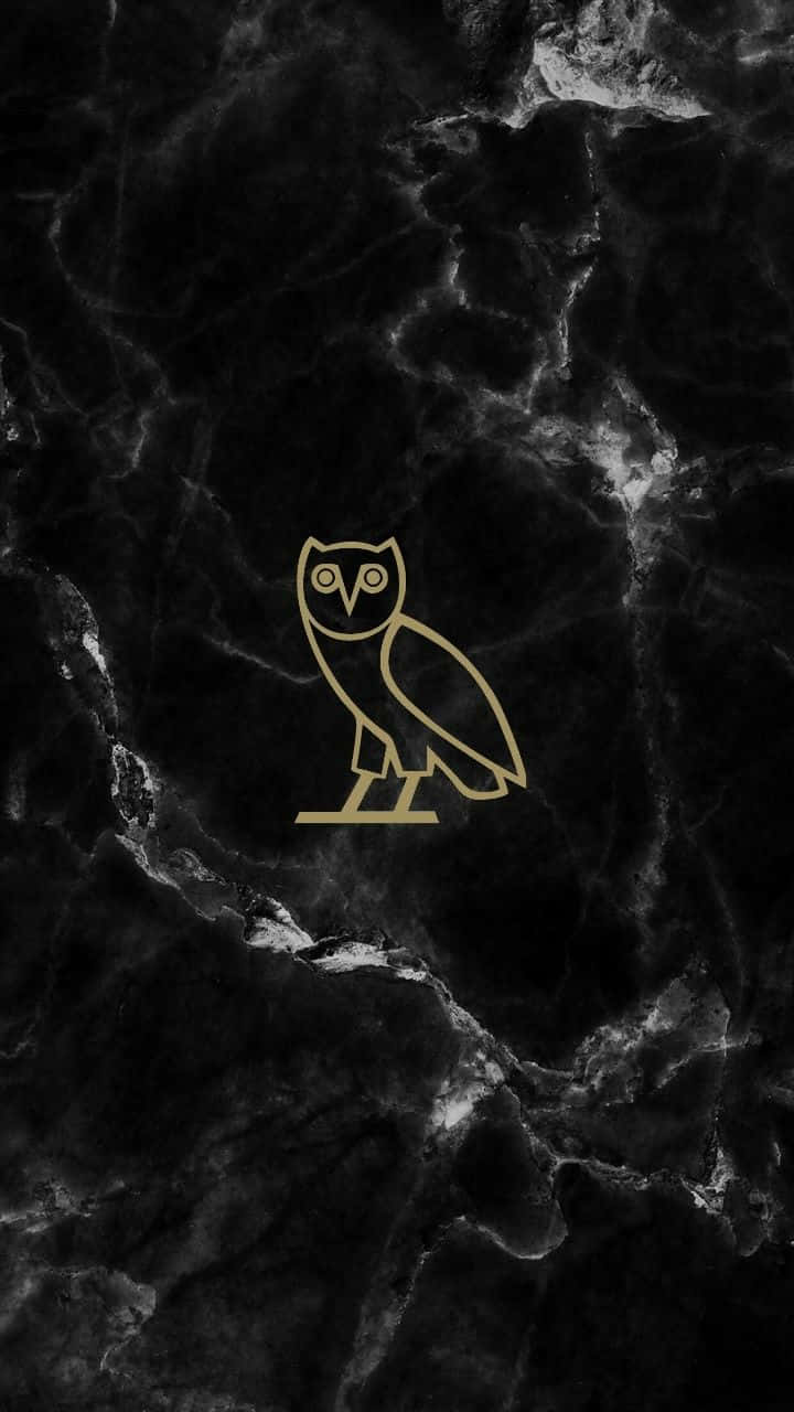 A Gold Owl Logo On A Black Marble Background Wallpaper