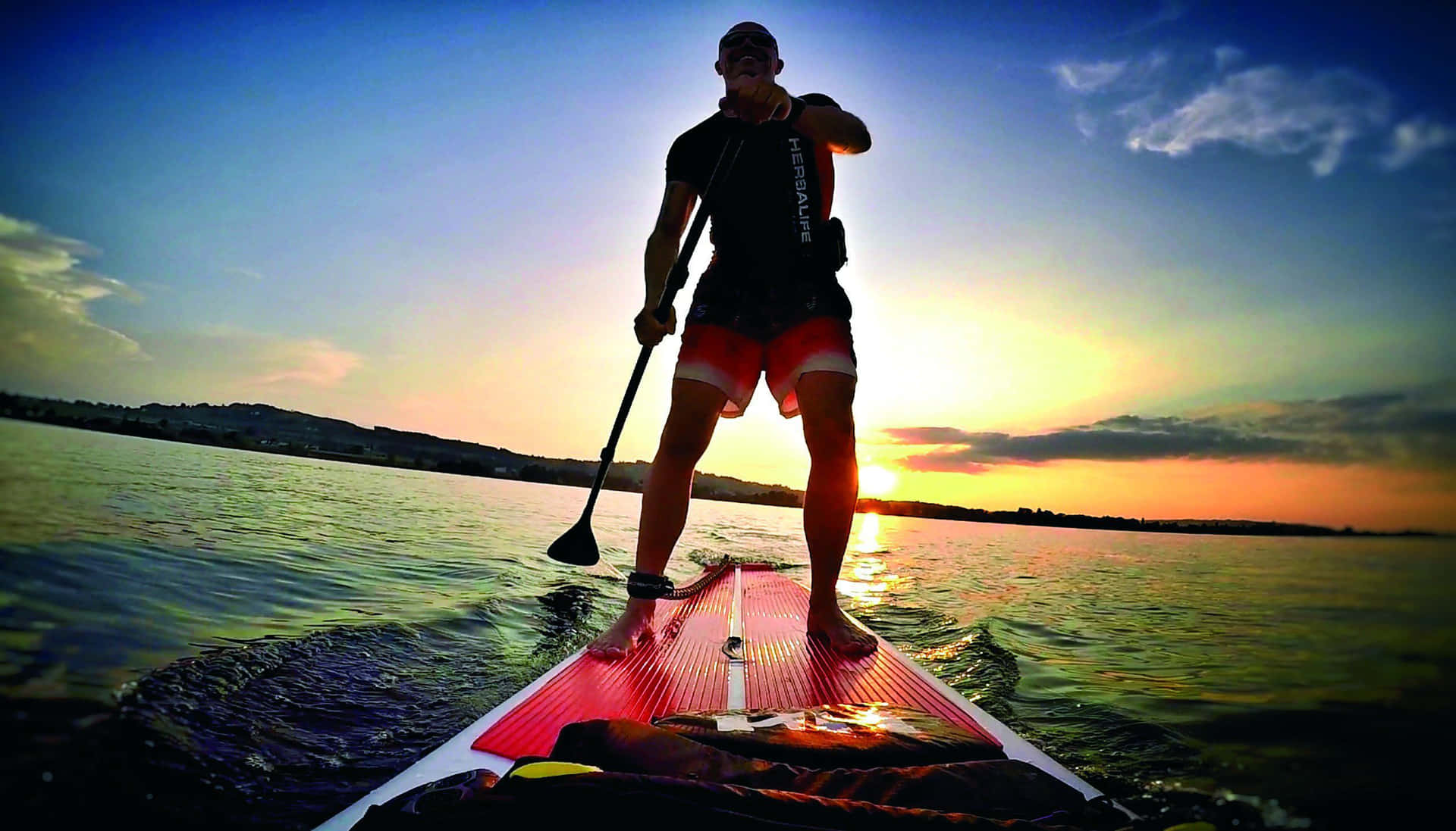 A serene paddleboarding experience at dusk Wallpaper