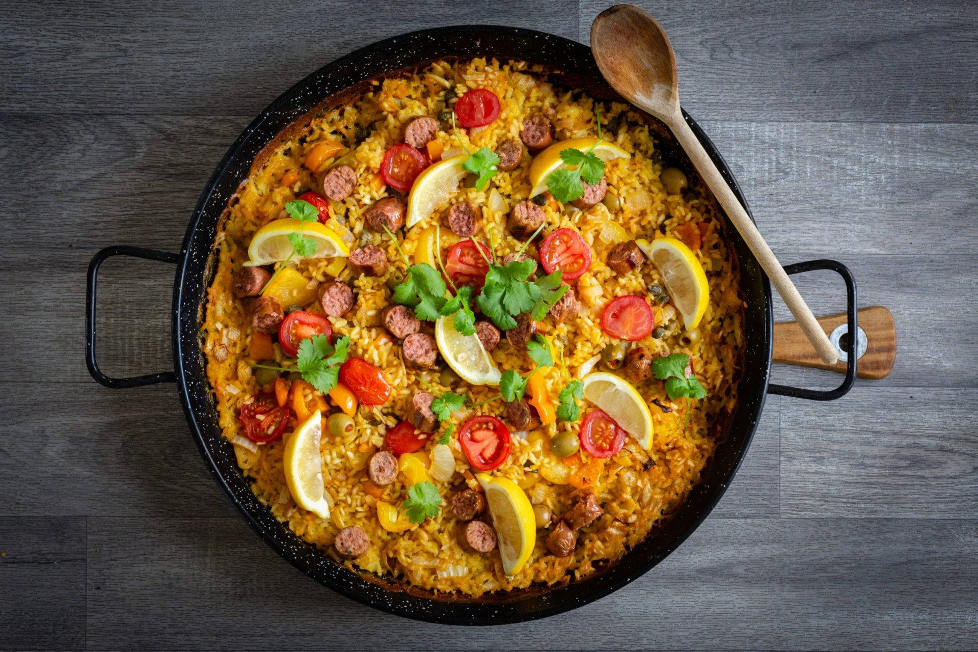 Paella Dish With Lemons And Sausages Wallpaper