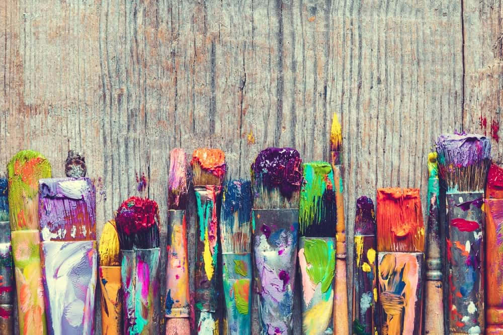 Colorful Paint Brushes On A Wooden Background