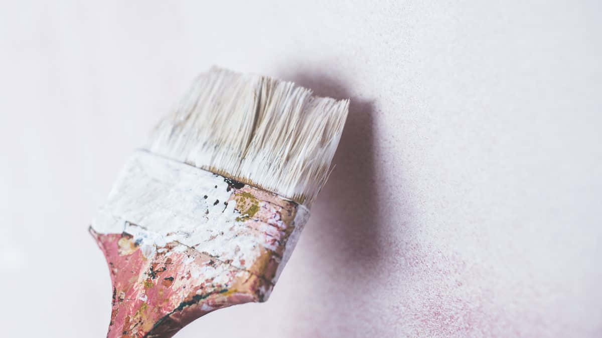 a paint brush on a pink wall