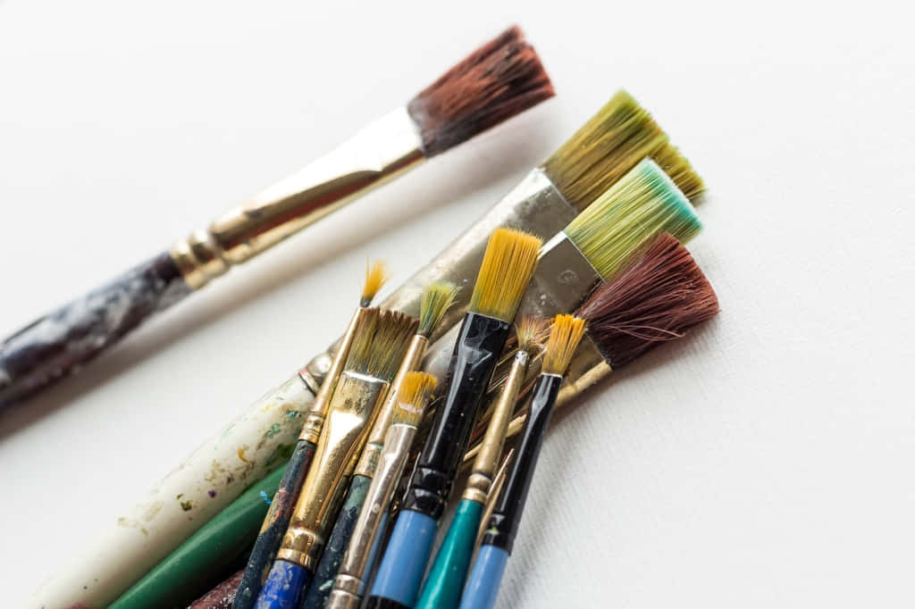 A Group Of Different Colored Brushes On A White Surface
