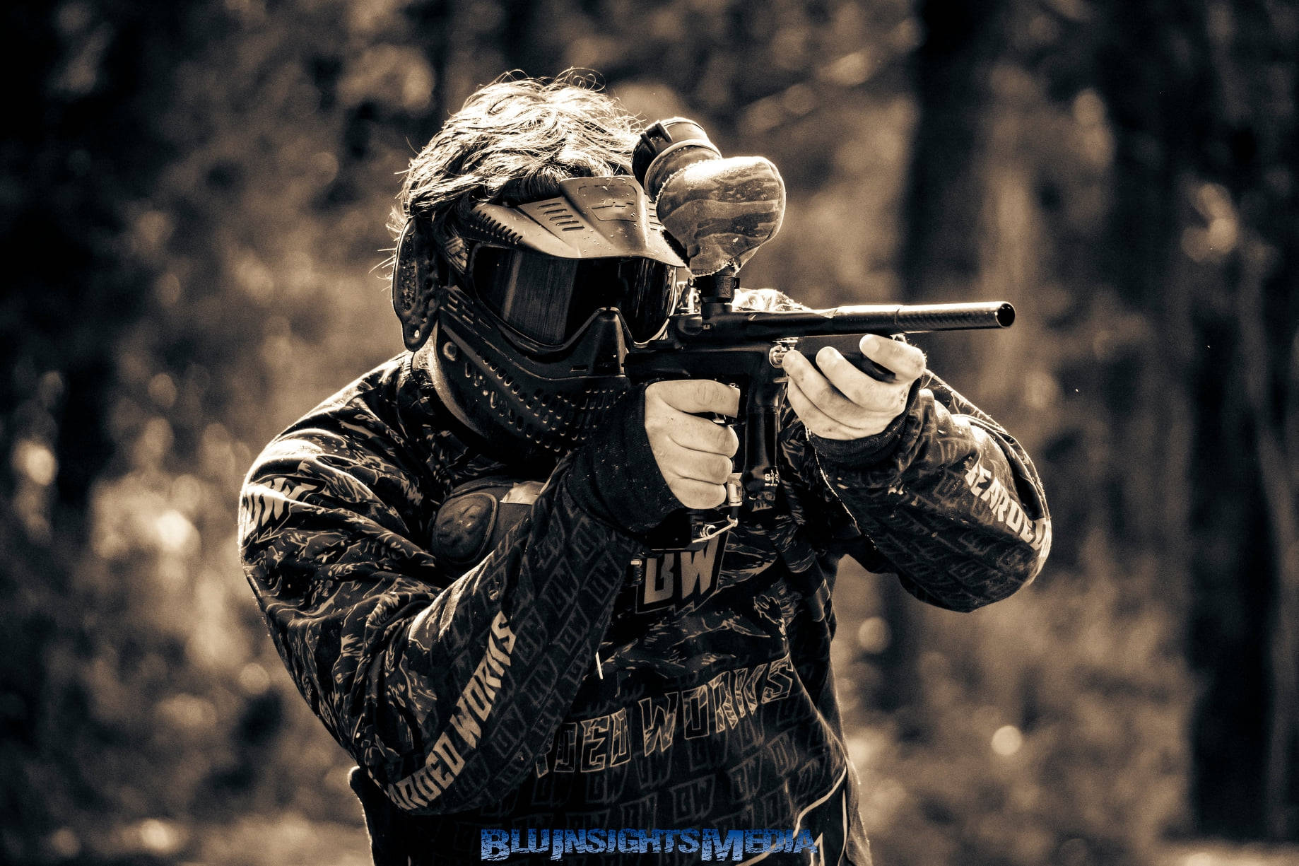 Download Paintball Player Aiming In the Woods Wallpaper | Wallpapers.com