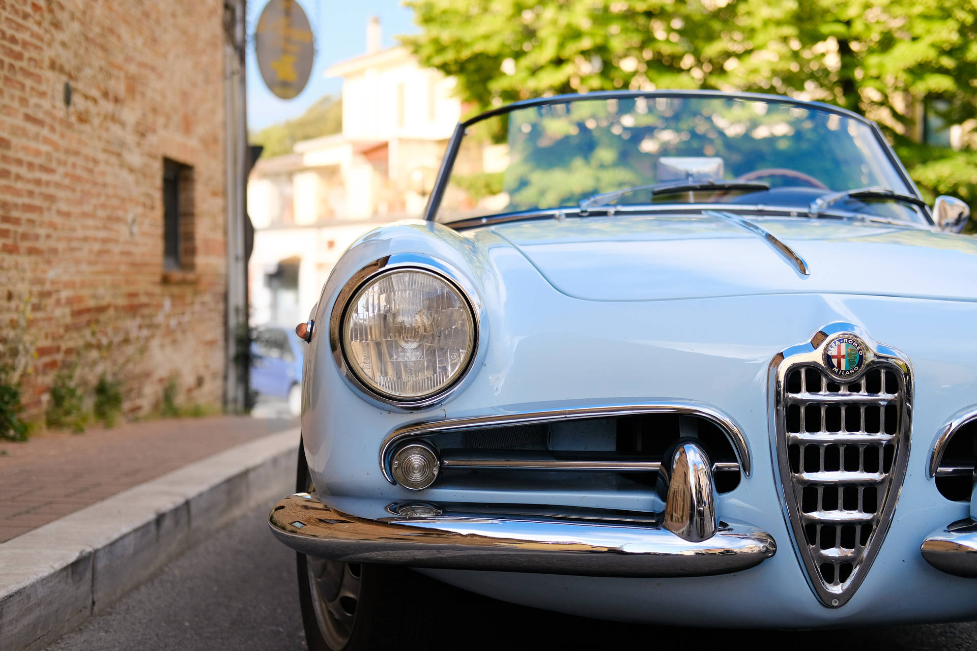 Pale blue Alfa Romeo Giulietta Spider classic car on street wallpaper.