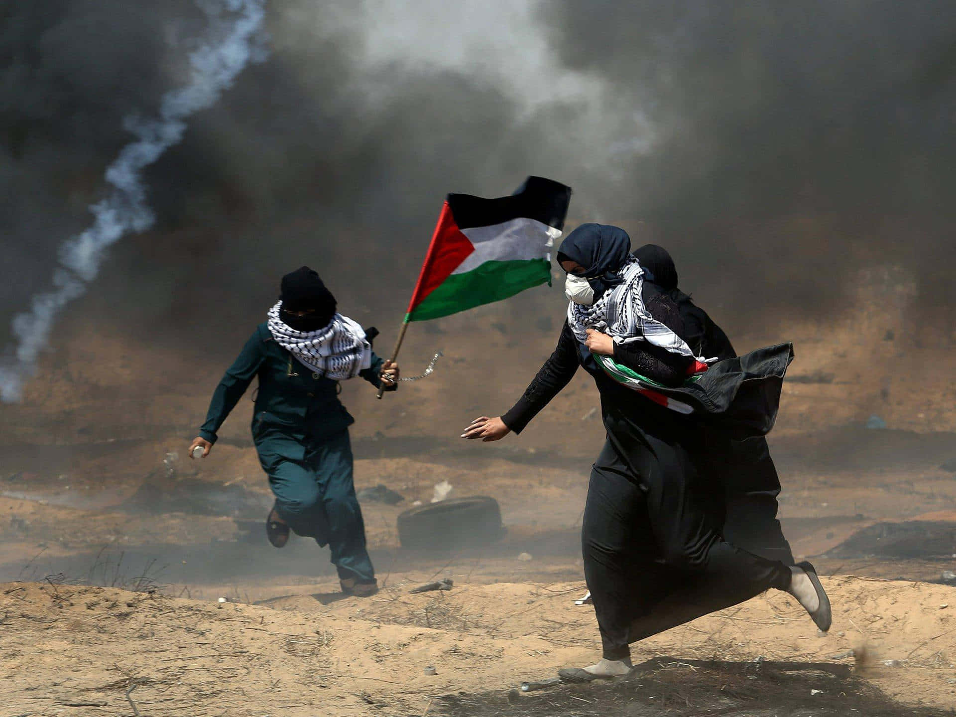 Two Women Running With A Palestinian Flag